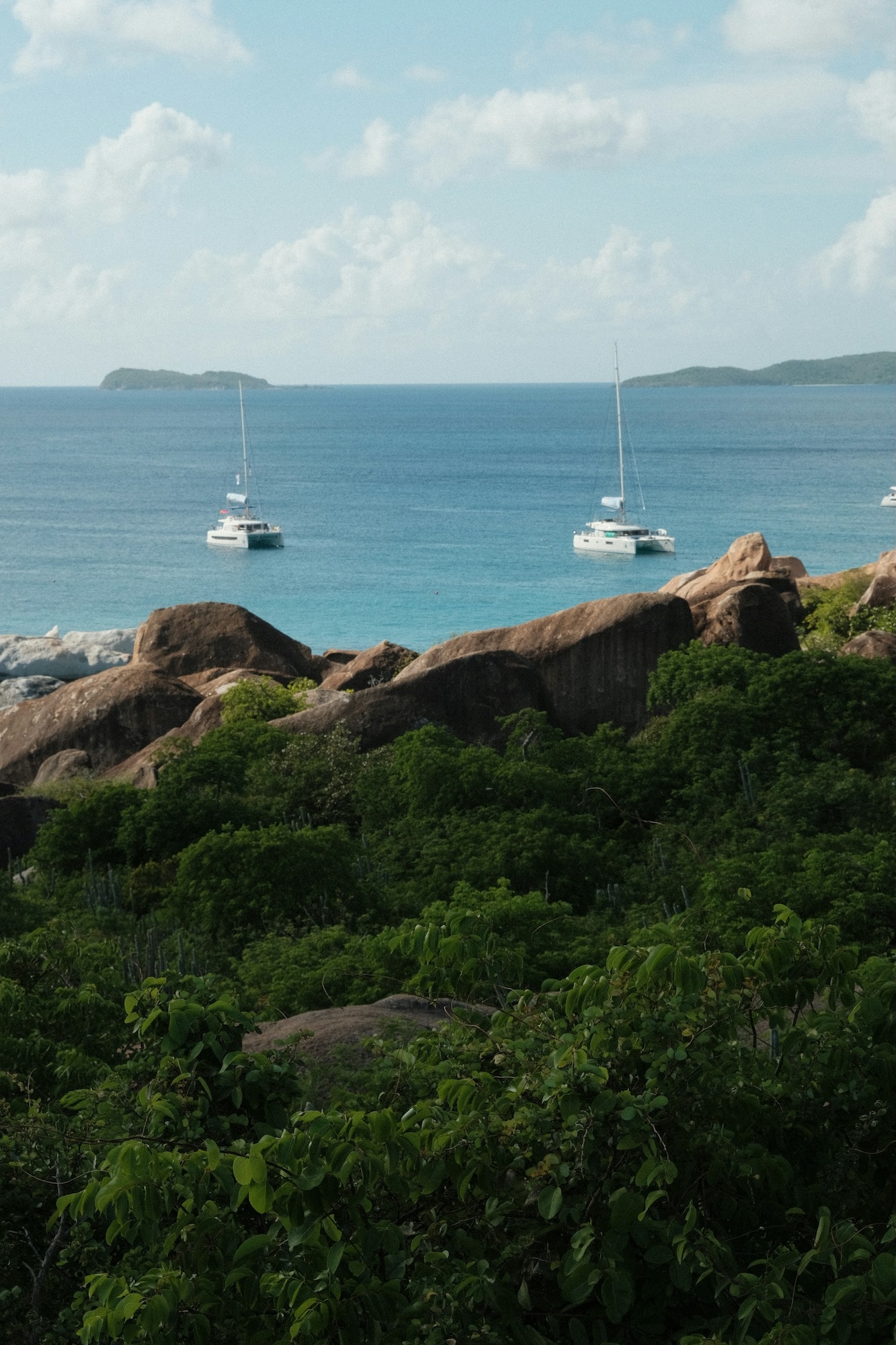 Sailboats off the lush Virgin Gorda coastline during a St. Thomas Charter Boats day charter