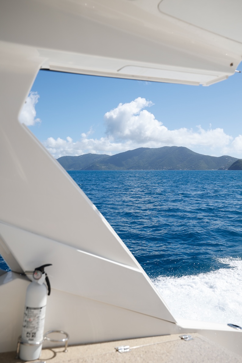 St. Thomas Charter Boats cruising past a mountainous island.